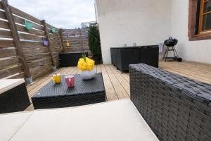 a patio with two benches and a table with flowers at Maison cosy 4-6 pers avec terrasse Lac & hyper centre à pied 300 m Linge inclus in Gérardmer