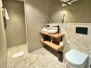 a bathroom with a toilet and a sink and a shower at Schuhbauers Oberwirt - digitale Self-Check-in Apartments in Schnotting