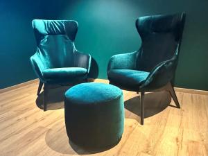 two chairs and a ottoman in a room at Schuhbauers Oberwirt - digitale Self-Check-in Apartments in Schnotting