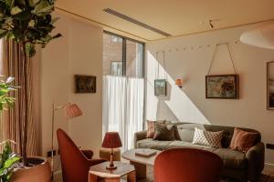 a living room with a couch and a table at Wilde Cambridge City Centre in Cambridge
