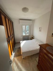 a bedroom with a bed and a dresser and a window at Casa Bice in Misano Adriatico
