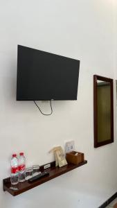 a flat screen tv on a wall with a shelf at Bawangan Express in Ngadisari
