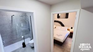 a bathroom with a bed and a shower in a room at O Palheiro in Biscoitos +23 photos