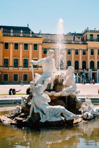 a fountain in front of a building with a water fountain at grätzlhotel Serviten in Vienna