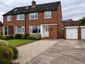 a brick house with a garage and a driveway at Westbrook Spacious 3 Bed in Exeter in Pinhoe