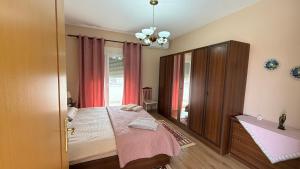 a bedroom with a bed and a large window at Belvedere Centro Shkoder in Shkodër