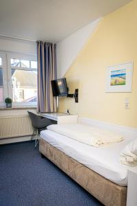 a hotel room with a bed and a television at FineApartment Alt Duvenstedt in Alt Duvenstedt