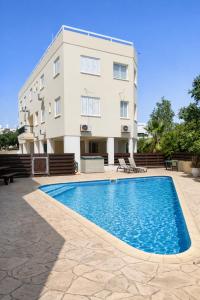 a building with a swimming pool in front of a building at Pantelia Apartment Paralimni in Paralimni