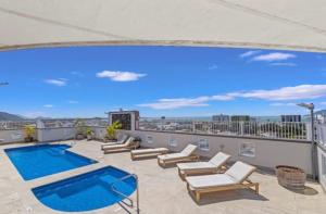 a patio with a swimming pool on top of a building at Prime CBD High Rise Apartment in Cairns