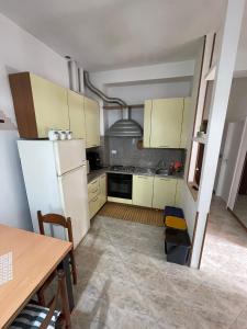 a kitchen with yellow cabinets and a white refrigerator at Casa Bice in Misano Adriatico