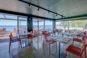 a restaurant with tables and chairs and a view of the water at Hotel Flaminia in Sirmione