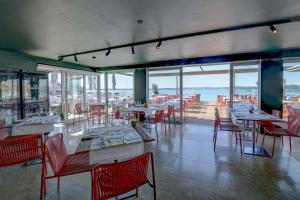 a restaurant with tables and chairs and a view of the ocean at Hotel Flaminia in Sirmione