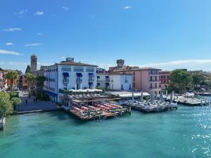 a group of boats docked in a river with buildings at Hotel Flaminia in Sirmione +64 photos
