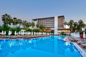 a swimming pool with chairs and umbrellas and a hotel at Royal Garden Beach Hotel in Konaklı