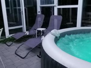 two chairs and a hot tub in a building at Greenwood Cottage house for rent near Zagreb in Pisarovina