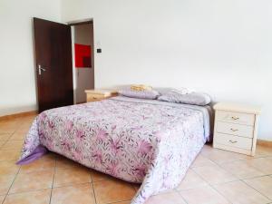 a bedroom with a bed with a pink comforter at Levico Centrale Apartment in Levico Terme +3 photos