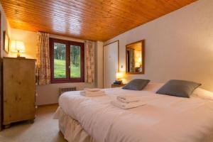 a bedroom with a large white bed with towels on it at Résidence Igloo in Chamonix