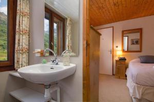 a bathroom with a sink and a bed and a window at Résidence Igloo in Chamonix