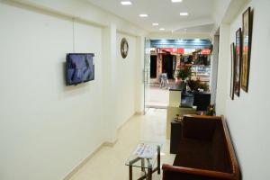 a hallway with a couch and a tv on a wall at Hotel Landmark in Ooty
