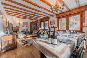 a dining room with a table with wine bottles on it at Chalet Ecureuil Family retreat w/ Garden & Fireplace - Happy Rentals in Chamonix