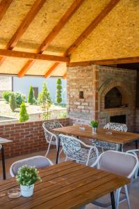 an outdoor patio with wooden tables and a fireplace at Apartmani Maja in Rastište