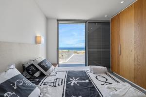 a bedroom with a bed with a view of the ocean at Casa do Azimute by Real Vision in Porto Santo +14 photos