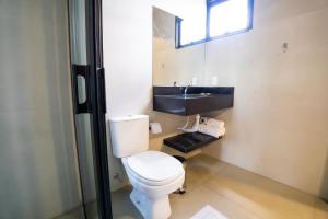 a bathroom with a toilet and a sink at Barak Hotel in Nova Mutum