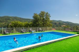 a group of people swimming in a swimming pool at Apartmani Maja in Rastište