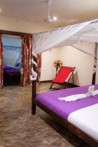 a bedroom with a bed and a red chair at Le Moya Beach in Nosy Be +74 photos