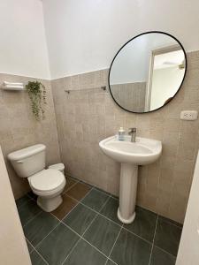 a bathroom with a toilet and a sink and a mirror at las gaviotas in Bayahibe +9 photos
