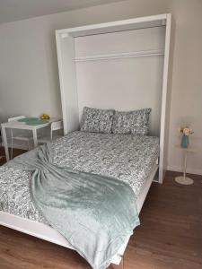 a white bed in a bedroom with a white headboard at Casa da Avo Ilda - Near the Sea in Matosinhos