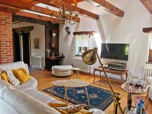 a living room with a white couch and a tv at Greenwood Cottage house for rent near Zagreb in Pisarovina