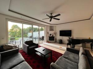 a living room with a ceiling fan and a piano at Große Terrassenwohnung mit Seeblick in Stechlin