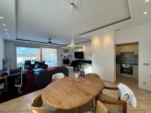 a dining room and living room with a wooden table at Große Terrassenwohnung mit Seeblick in Stechlin