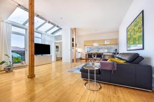 a living room with a black couch and a table at Landhaus Bleckede - App 2 Lüneburg in Bleckede