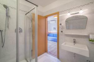 a bathroom with a shower and a sink and a mirror at Gartenheim App Verena in Schenna +12 photos