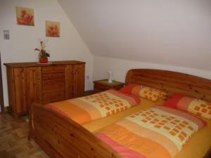 a bedroom with two beds and a dresser at Ferienwohnung Wassergartenparadies in Harsdorf