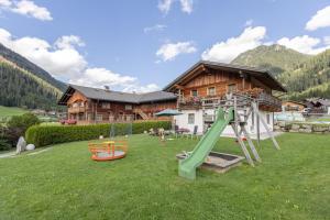 a playground in front of a log house at Obermarhof Gsies in Prateria