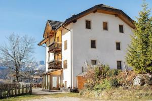 ein großes weißes Gebäude mit einem Holzdach in der Unterkunft Ciablun in Wengen