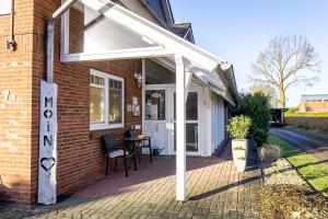 awning on the side of a house with a patio at FineApartment Alt Duvenstedt in Alt Duvenstedt