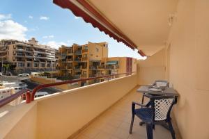 a balcony with a table and chairs and a view of buildings at La Casita de Edu in Puerto de Santiago