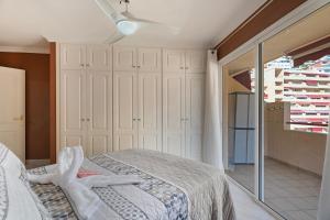 a bedroom with a bed and a sliding glass door at La Casita de Edu in Puerto de Santiago +17 photos