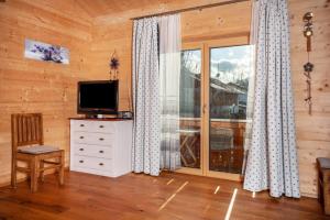 a living room with a television and a large window at Ferien Bei Mari in Schwangau