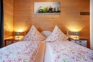 two beds in a room with wooden walls at Ferien Bei Mari in Schwangau