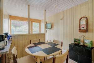 a kitchen with a table and chairs in a room at La maison de la Rebergère in Javené