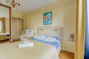 a bedroom with a large white bed with a mirror at La maison de la Rebergère in Javené