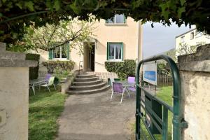 a building with purple chairs in front of a building at Luchon Maison Flor in Luchon