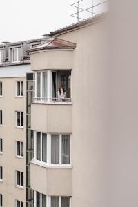 a woman looking out the window of a building at URBANAUTS FLATS Cubierta in Linz