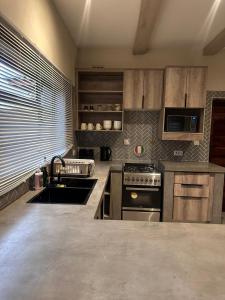 a kitchen with a sink and a stove at Imbarudo Residence in Victoria Falls +8 photos