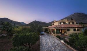 a large house with mountains in the background at Can Magraner in Port de Pollensa